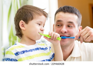 Man And Son Kid Brushing Teeth In Bathroom