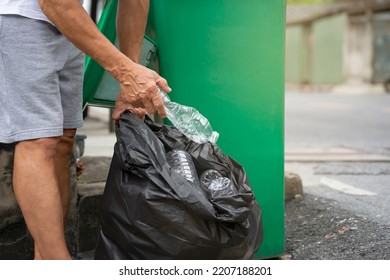 man sorting plastic bottles in garbage disposal point in front of a house in the city before a garbage truck comes to collect them.concept home sorting recycle plastic bottles to reduce global warming - Shutterstock ID 2207188201