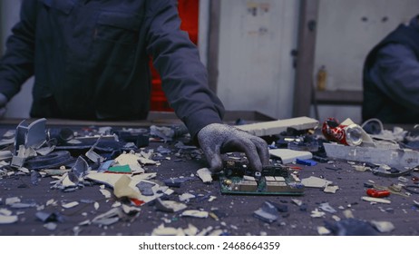 Man sorts garbage, electronics or plastic. Taking care of the environment. Waste recycling plant or garbage factory. Conveyor belt, trash moving along the line. Male have a eco-friendly work