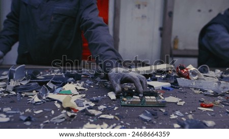 Man sorts garbage, electronics or plastic. Taking care of the environment. Waste recycling plant or garbage factory. Conveyor belt, trash moving along the line. Male have a eco-friendly work