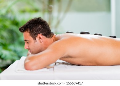 Man at the spa getting a hot stone massage 
