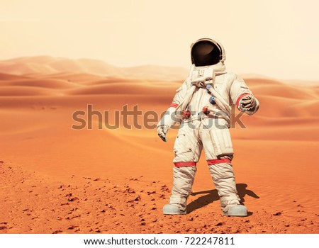 Man in a space suit standing on the red planet Mars. Spaceman conquer a new planet. Concept of the space 
