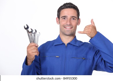 Man With Spanners Making A Call Me Sign With His Hand