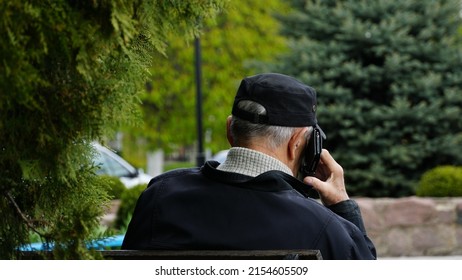 A Man Speaks On The Phone On The Street. The Phone Is Attached To The Ear. View From The Back. N