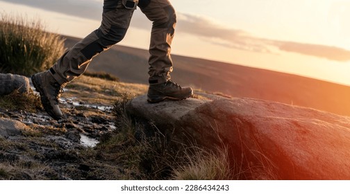 man in special boots walking in the mountains reaching the destination and on the top of mountain in Peak District at sunset  Travel  Lifestyle concept - Powered by Shutterstock