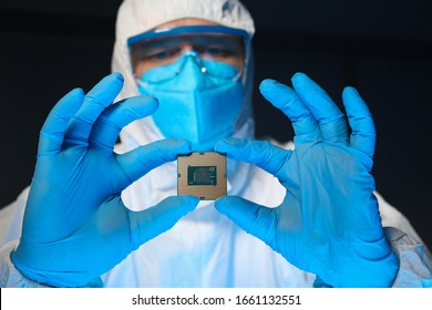 Man in special uniform shows microprocessor chip. Software-controlled device for processing information. Production technology. Development special chip. Scientist is engaged in chip implementation