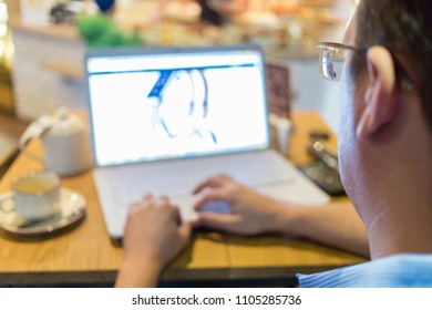man spectacled looking at his computer at cafe, focus on man