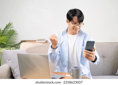 Man with spectacles relaxing sitting on couch while looking at mobile phone. Close up of mature man using smartphone to checking email at home. Man reading email on smartphone - Shutterstock ID 2258623037