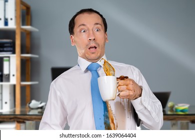 Man Spilling Coffee On On His Shirt In Office