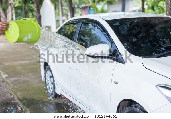 Man Splashing\
water to white car for\
washing