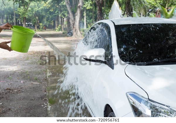 Man Splashing\
water to white car for\
washing