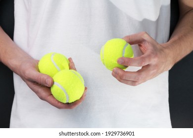 a man in a sports white tennis uniform holds balls. playing tennis. close-up