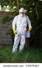 Man Spraying Pesticide On Grass In Lawn