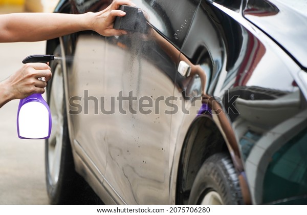 Man spraying wax and varnish with\
clay,Automobile industry. Car wash and coating business with\
ceramic coating.Spraying the varnish to the car. Concept of: Car\
protective, Service,\
Shine.\
