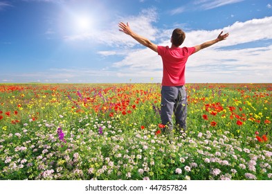 Man In Spring Meadow Of Flower. Emotional Scene.