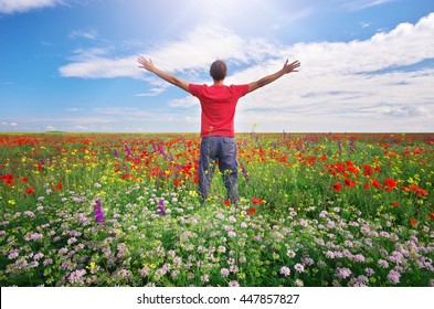 Man In Spring Meadow Of Flower. Emotional Scene.