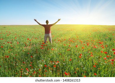 Man In Spring Meadow Of Poppy Reach To Sun. Happy Emotional Religion And Conceptual Scene.