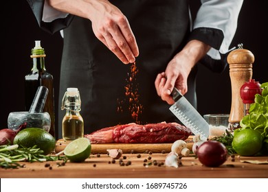 Man sprinkles paprika over meat. Raw beef steak being seasoned with pepper, lime, onion, garlic and olive oil. - Powered by Shutterstock