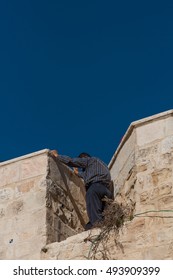 Man spying above a ancient, tall wall in Jerusalem, Israel