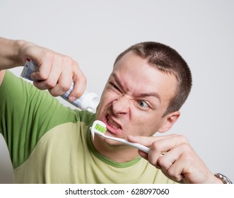 Man Squeezing Toothpaste On The Brush