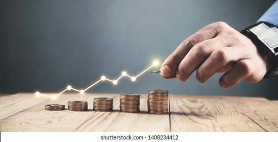  Man stacking coins with a graph of profit. - Shutterstock ID 1408234412