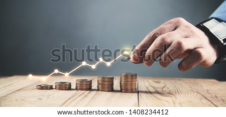 Man stacking coins with a graph of profit.