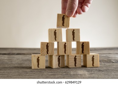 Man stacking a tower of wood blocks with human silhouettes, human resources and management concept. - Shutterstock ID 629849129