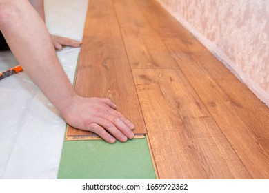 Man stacks a parquet board. Repair floor work in the apartment. Repair concept. - Shutterstock ID 1659992362