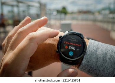 A man at the stadium checks the number of calories burned in his smartwatch. Daily exercise in the fresh air for weight loss. Smart gadgets for sports. wristwatch concept - Powered by Shutterstock