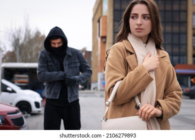 Man Stalking Young Woman On City Street