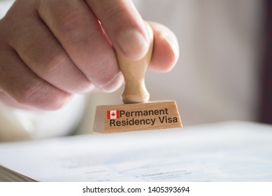A man and a stamp for a visa for Canada - Shutterstock ID 1405393694