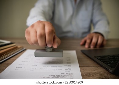 man stamping approval Text is approved by stamping the document on paper. - Shutterstock ID 2250914209