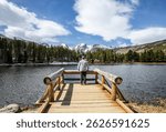 A man stand at the dock on Sprague Lake admiring the amazing view in Rocky Mountain National Park in Colorado. 