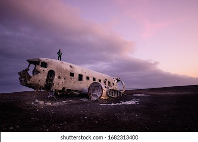 the man stand on the  abandoned DC Plane on Sólheimasandur in Iceland as one of the tourist destination