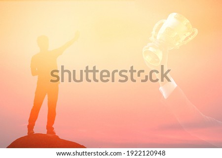 man stand on the rock point his hand at the golden trophy in business hand target of worker , worker concept