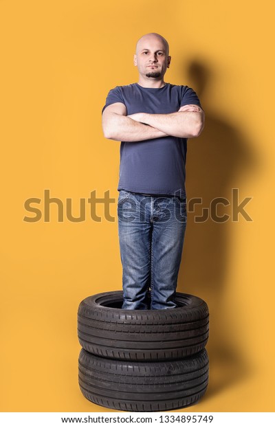 man standing\
in automobile tires .changing\
time