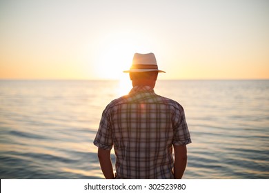 man standing backlight sunset lighting back view summer evening beach lens flare