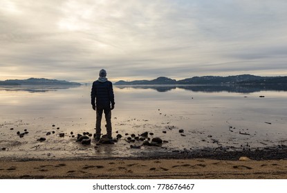 Man Standing At The Beach, Looking At The Calm Sea And The Mist And Fog. Hamresanden, Kristiansand, Norway