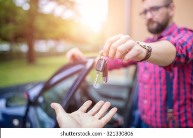 Man Standing By The Car And Giving Back Car Keys