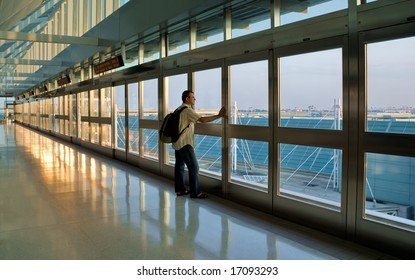 Man standing by a window and waiting his flight, Pearson International Airport, Toronto, Canada.