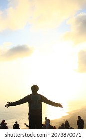 A man is standing facing the sun 