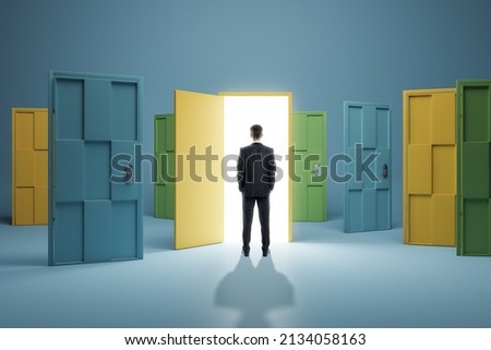 Man standing in front of abstract colorful puzzle door in interior. Future, choice, success, direction, opportunity and solution concept