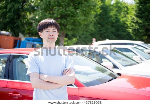Man standing in front of\
car