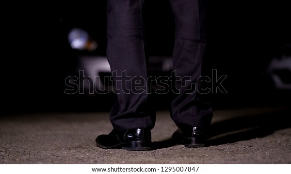 Man standing in front of car on parking,\
going to nightclub party,\
entertainment