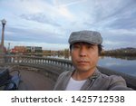 a man standing in front of magog river at promenade du lac des nations at rue de l