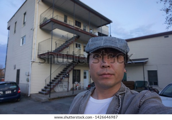 a man standing in front of residence\
houses at rue alexandre of sherbrooke town on the townships trail\
of eastern townships in quebec,\
canada
