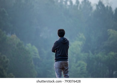 Man standing in front of tree in forest in the morning time
