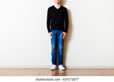 Man standing in front of the wall of the room - Shutterstock ID 619171877