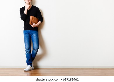 Man standing in front of the wall of the room - Shutterstock ID 619191461