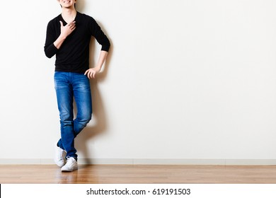 Man standing in front of the wall of the room - Shutterstock ID 619191503